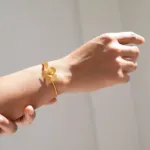 Mano mostrando Hoja de Lata con Joidart model pulsera pampalonia dorado